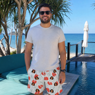 Real-life photo of someone wearing Men's Heartleaf Heat Custom Face Beach Shorts — custom faces printed all-over