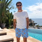 Real-life photo of someone wearing Men's Orb Weaver Custom Face Beach Shorts — custom faces printed all-over