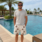 Real-life photo of someone wearing Men's Santa Satchels Custom Face Beach Shorts — custom faces printed all-over