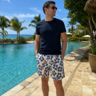 Real-life photo of someone wearing Men's Flora Fiesta Custom Face Beach Shorts — custom faces printed all-over