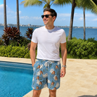 Real-life photo of someone wearing Men's Wisp Whimsy Custom Face Beach Shorts — custom faces printed all-over