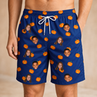 Model wearing Men's Orange Oddities Custom Face Beach Shorts printed with kids' faces