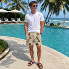 Real-life photo of someone wearing Men's Poinsettia Pop Custom Face Beach Shorts — custom faces printed all-over