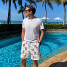 Real-life photo of someone wearing Men's Cake Craze Custom Face Beach Shorts — custom faces printed all-over