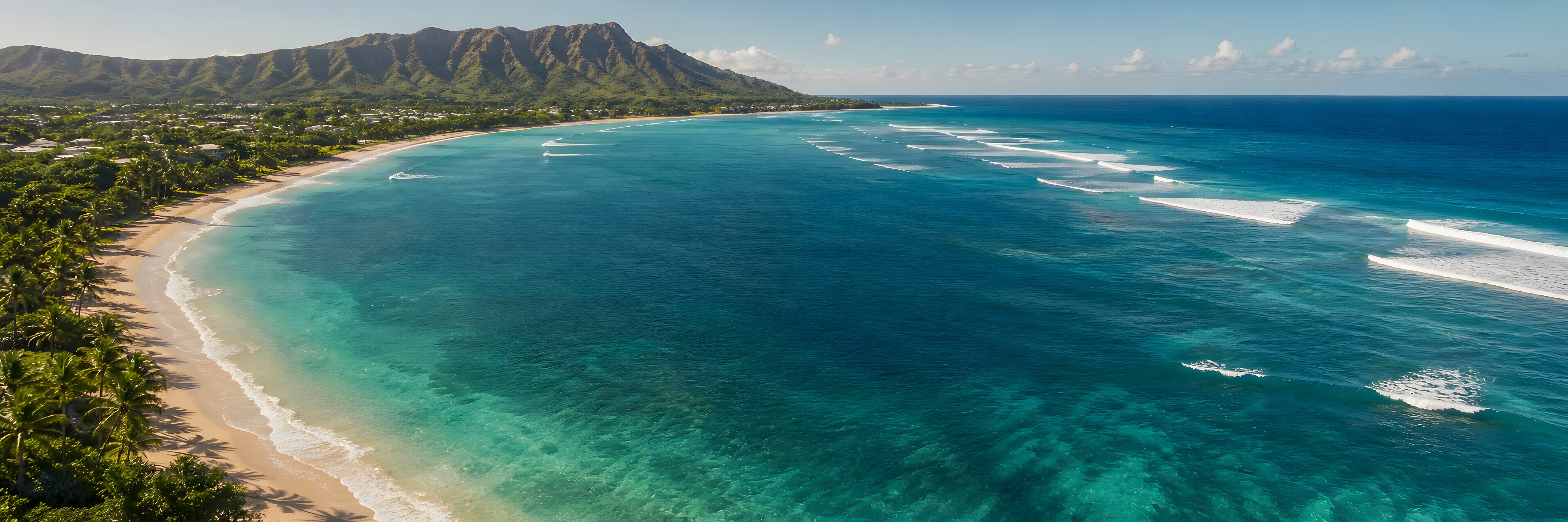 Aerial view of a tropical coastline with mountains, a sandy beach and turquoise ocean